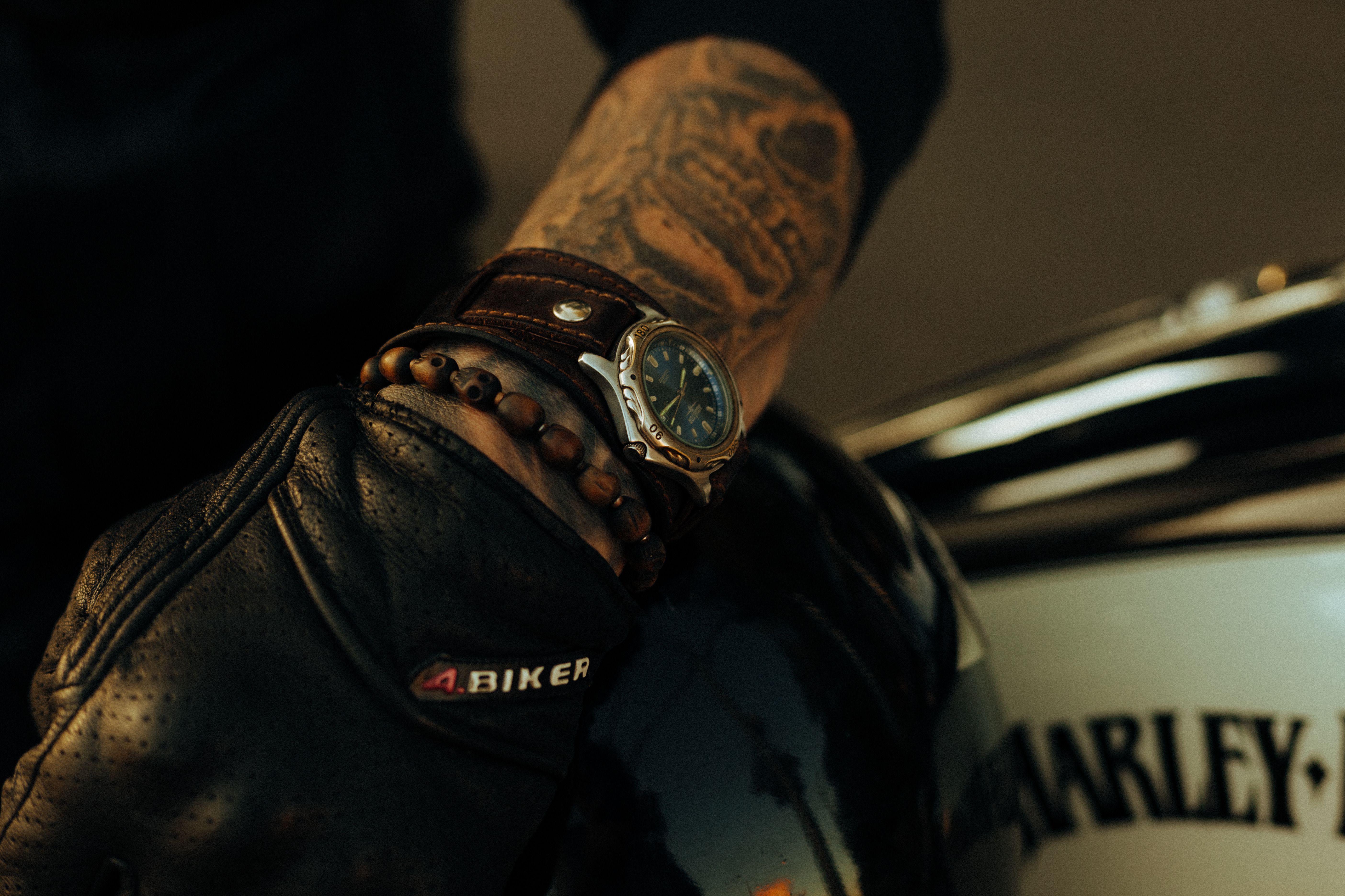 Rider wearing protective motorcycle gloves resting on a bike