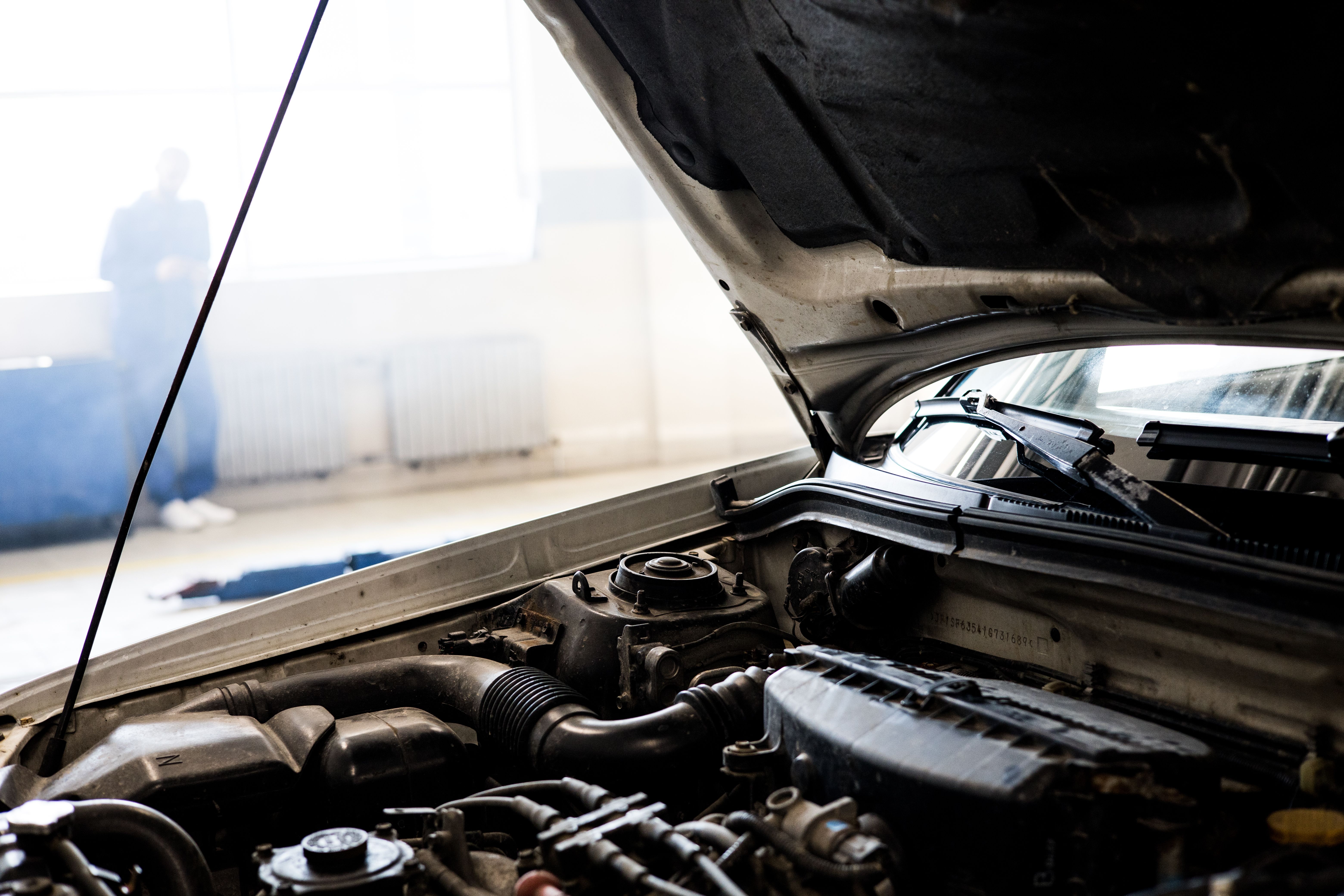 Detailed view of a car engine with the hood open in a workshop