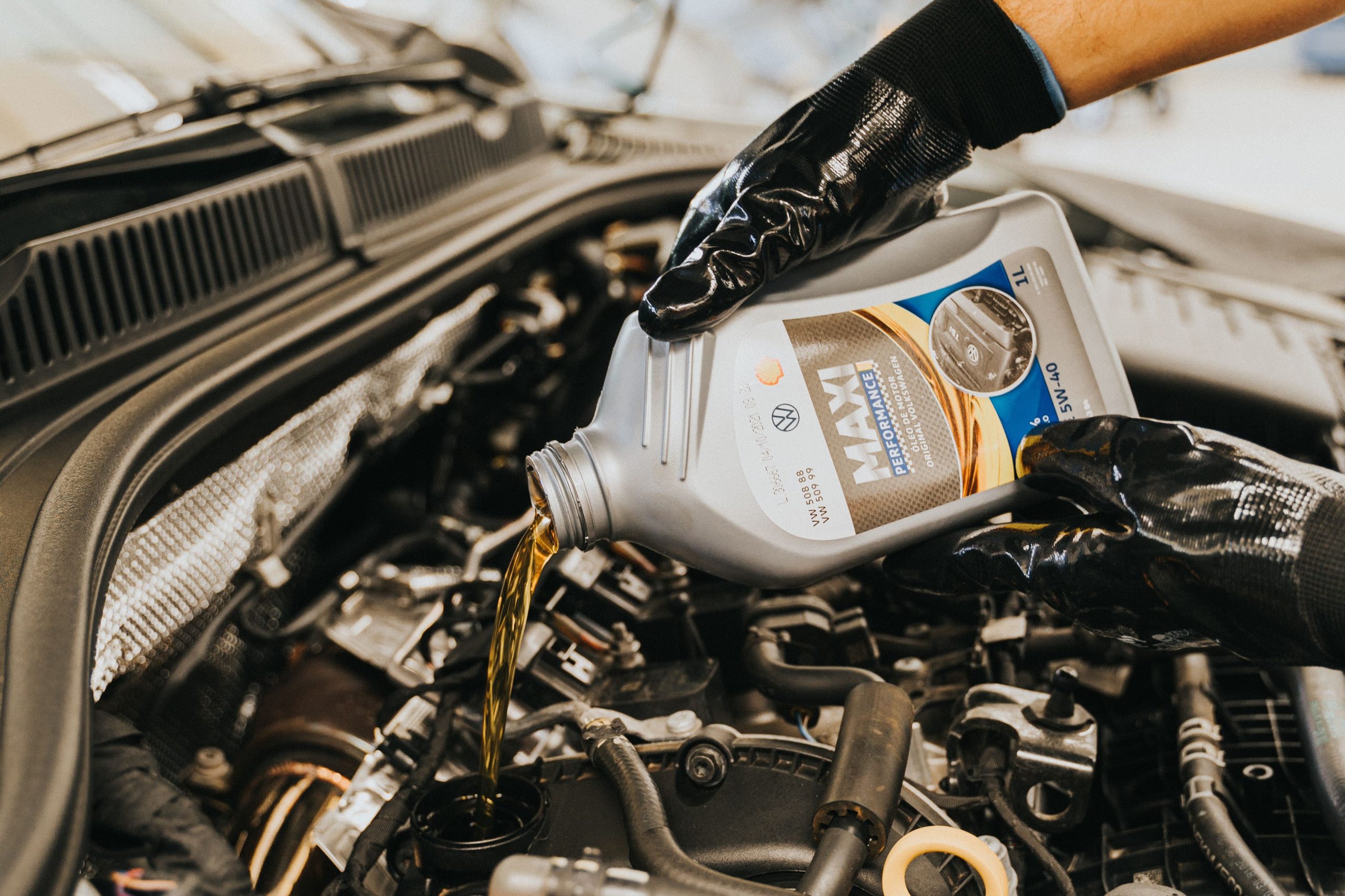 Mechanic carefully pouring engine oil into a car during routine maintenance